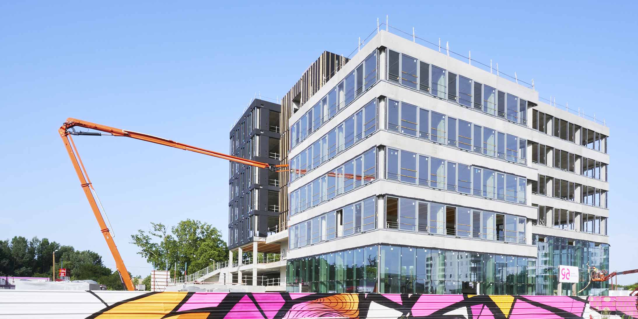 Chantier du siège Niwa, siège de GA Smart Building, illustrant la construction hors-site avec éléments préfabriqués en cours de pose